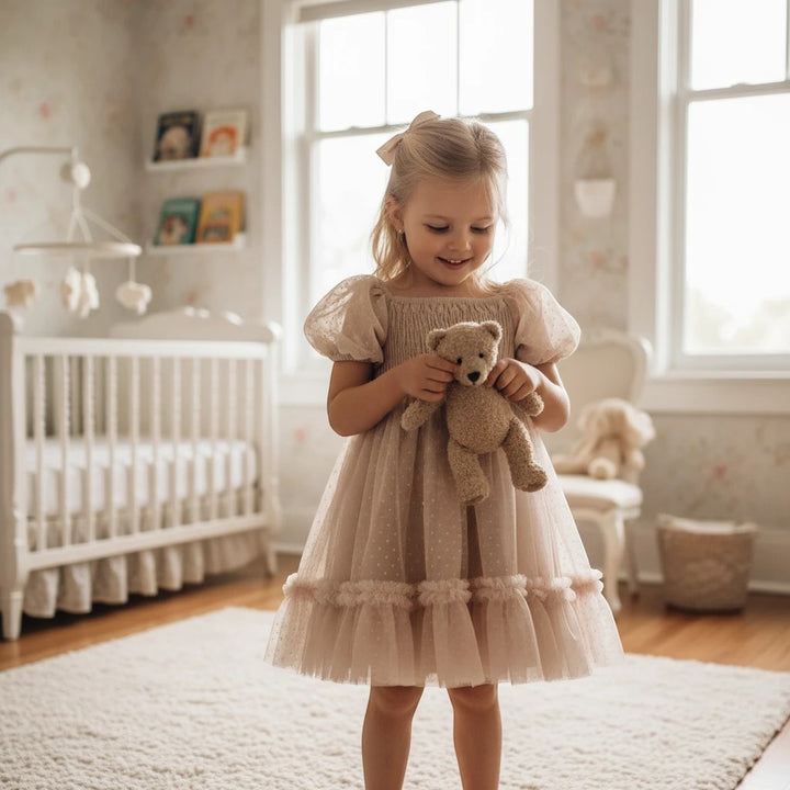Sea Dragon Dreams toddler girl blush tulle party dress with smocked bodice, puff sleeves, and shimmering polka dots.