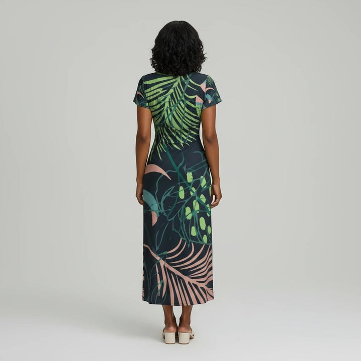 Back view of a Sea Dragon Dreams botanical print midi dress with flutter sleeves on a model against a grey background.