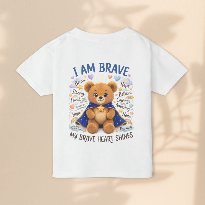 Sea Dragon Dreams white cotton toddler t-shirt featuring a cute teddy bear in a cape with I Am Brave text and rainbows.