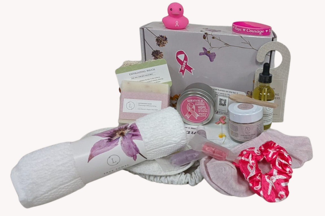 Sea Dragon Dreams breast cancer support gift box with natural spa items, lavender soap, candle, and pink awareness gear.