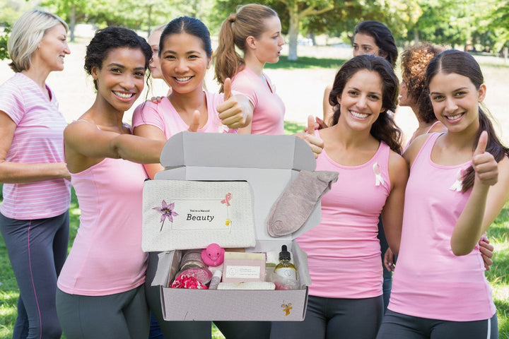 Sea Dragon Dreams breast cancer support gift box featuring natural spa items held by a group of women in pink shirts