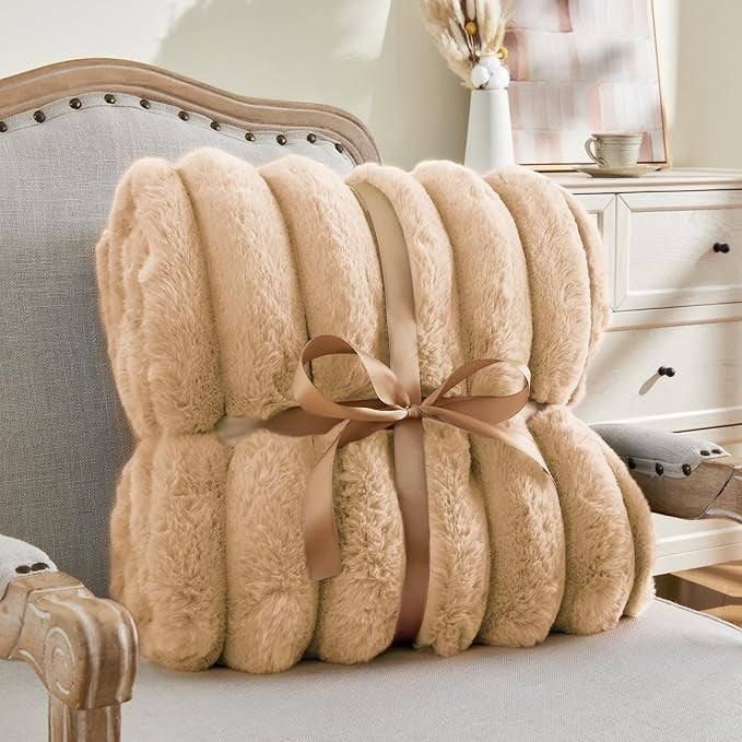 Sea Dragon Dreams BEDELITE brown faux rabbit fur throw blanket with 3D striped texture, tied with a ribbon on a chair.