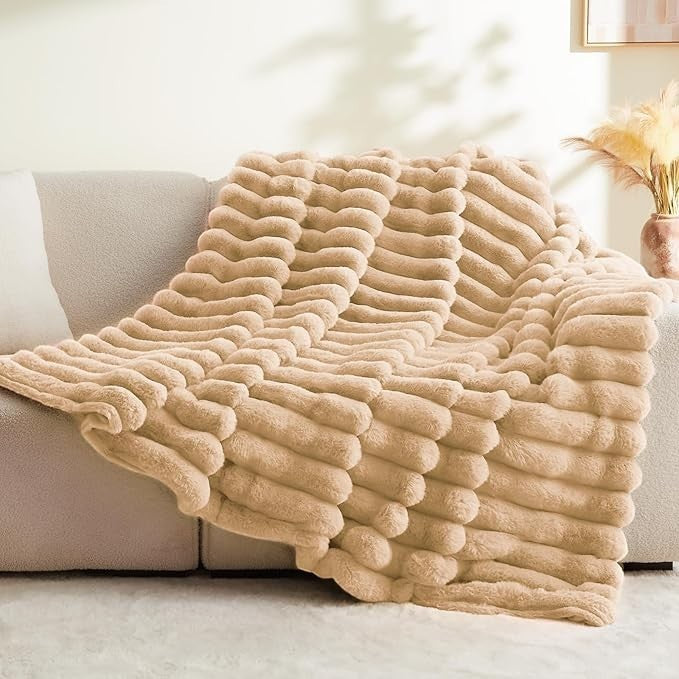 Sea Dragon Dreams BEDELITE brown faux rabbit fur throw blanket with 3D striped texture draped over a modern sofa.