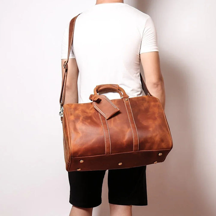 Sea Dragon Dreams Brandt Weekender brown horse leather duffle bag with shoulder strap worn by a man