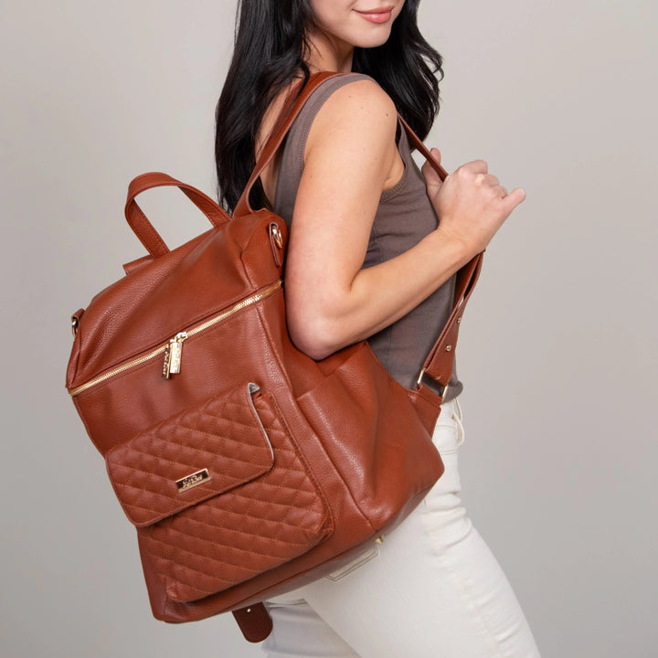 Sea Dragon Dreams Signature diaper bag in caramel brown vegan leather with quilted front pocket worn as a backpack