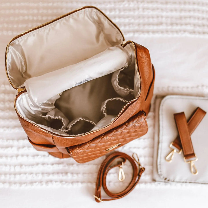 Sea Dragon Dreams Signature diaper bag in caramel brown vegan leather with open interior and included accessories.