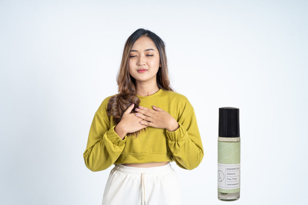 Sea Dragon Dreams CBD essential oil roll-on with tea tree, held by a woman in a yellow top practicing mindfulness