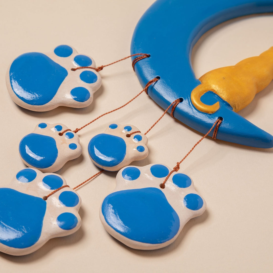 Sea Dragon Dreams handmade ceramic wind chime featuring a blue crescent moon and dangling blue and white paw prints.