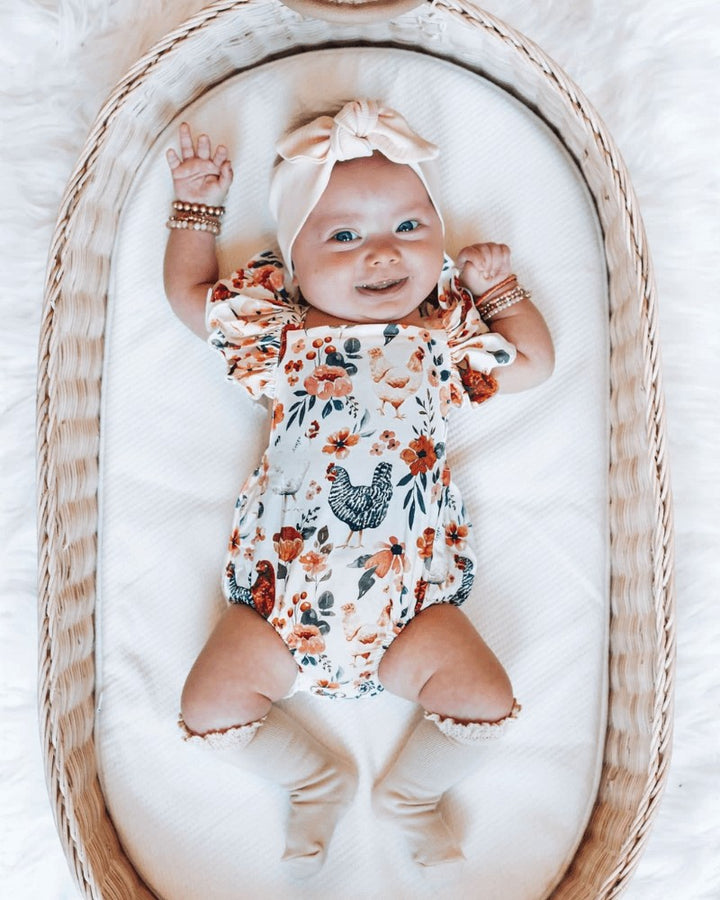 Sea Dragon Dreams baby romper with chicken and floral print, featuring ruffle sleeves and a bow headband