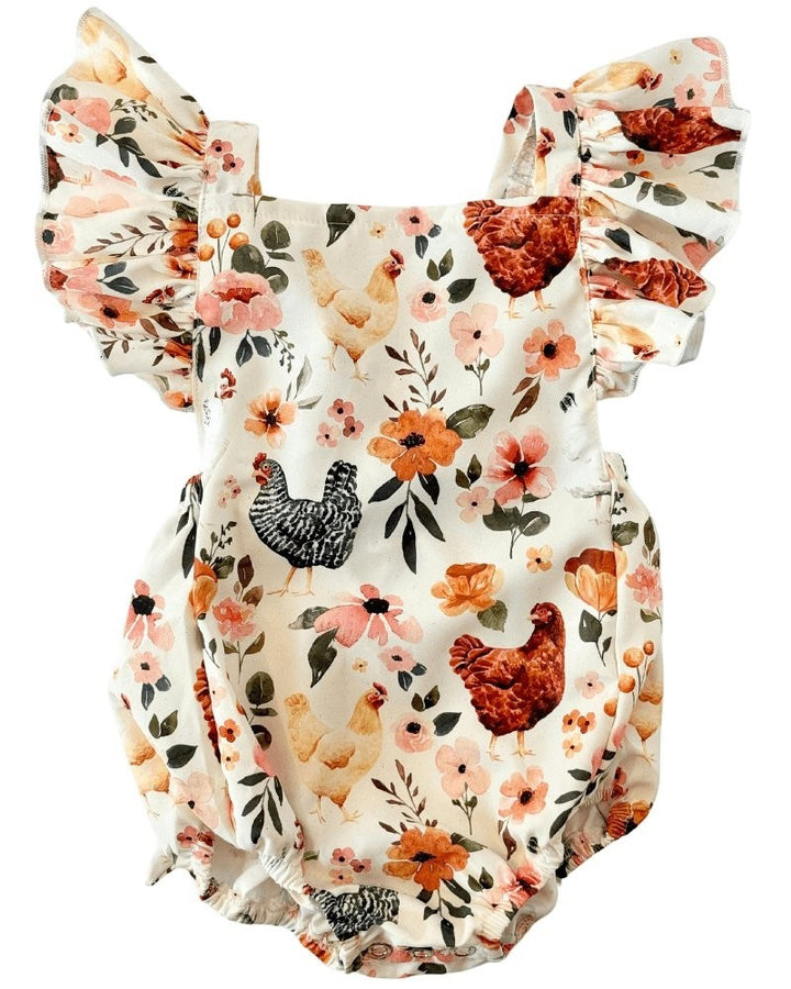 Sea Dragon Dreams baby romper in cream with a whimsical chicken and floral print, featuring ruffled shoulder straps.