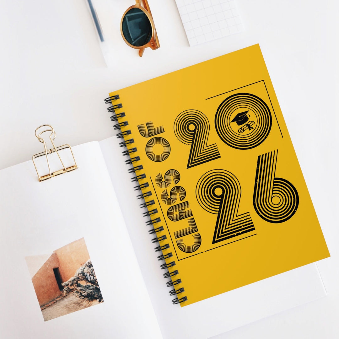 Sea Dragon Dreams Class of 2026 spiral notebook with a yellow cover and black typography on a white desk surface.