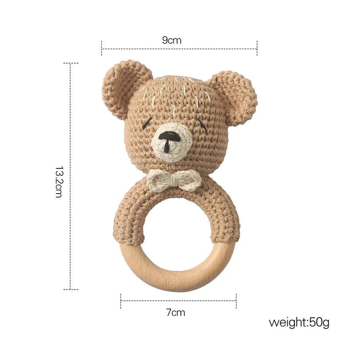 Sea Dragon Dreams crochet bear baby rattle with a wooden ring teether, soft beige cotton yarn, and cute bow detail.
