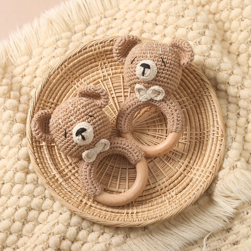 Sea Dragon Dreams crochet bear rattles with wooden rings on a woven basket, perfect for sensory play and teething.