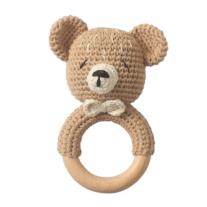 Sea Dragon Dreams crochet bear rattle with a wooden teether ring, featuring soft beige cotton and a gentle bell sound.