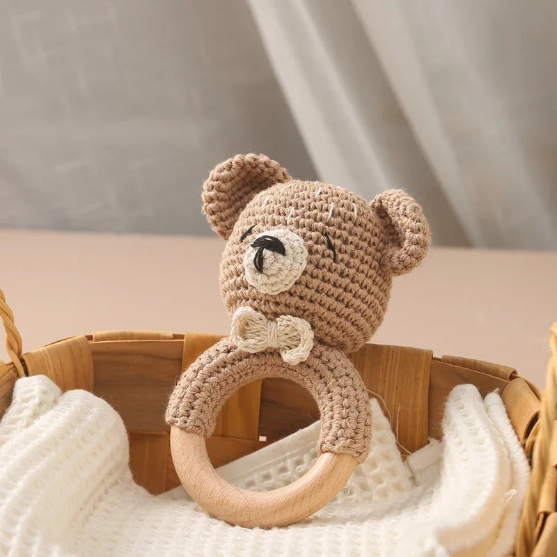 Sea Dragon Dreams crochet bear baby rattle with a wooden teether ring, soft cotton texture for sensory play.