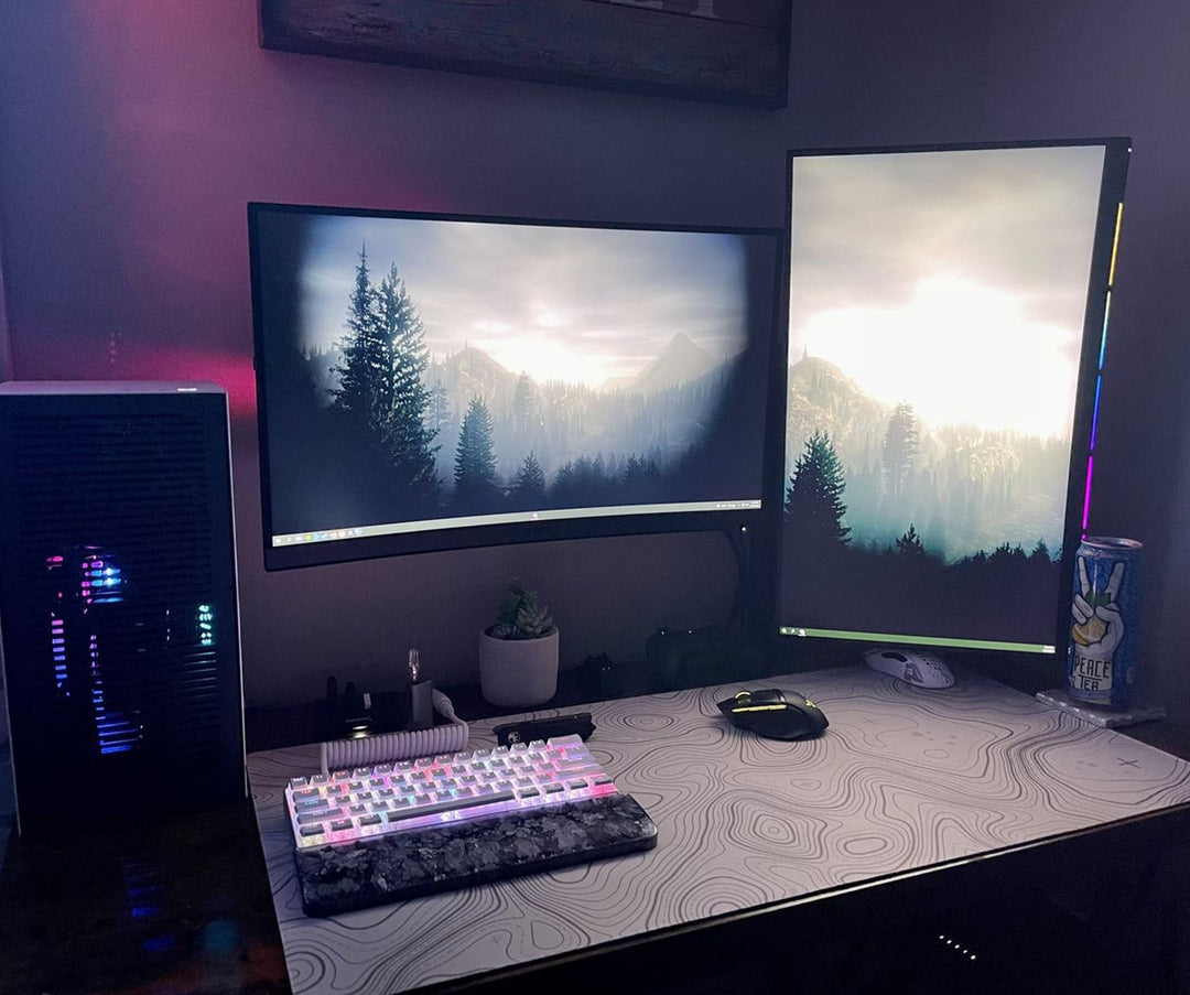 Sea Dragon Dreams custom XL desk mat with topographic map design on a gaming desk setup with dual monitors.