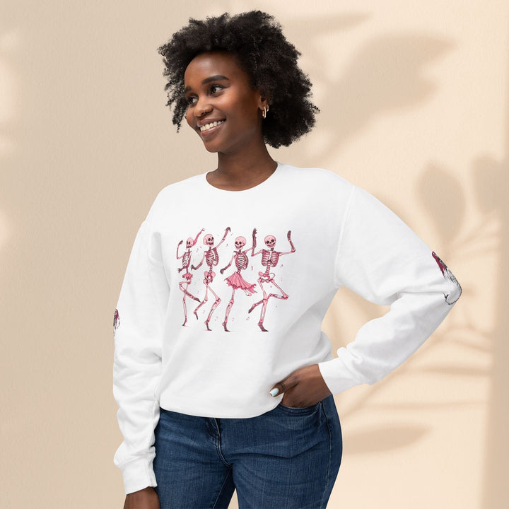 Sea Dragon Dreams white crewneck sweatshirt with dancing skeletons print worn by a smiling woman in blue jeans.