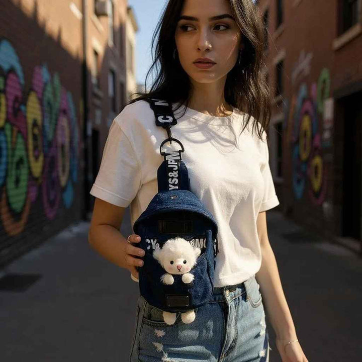 Sea Dragon Dreams kawaii denim crossbody sling bag with a cute sheep charm worn by a woman in an urban alleyway.