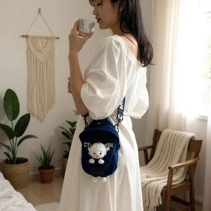 Sea Dragon Dreams kawaii denim crossbody bag with a cute sheep charm, worn by a woman in a white dress.