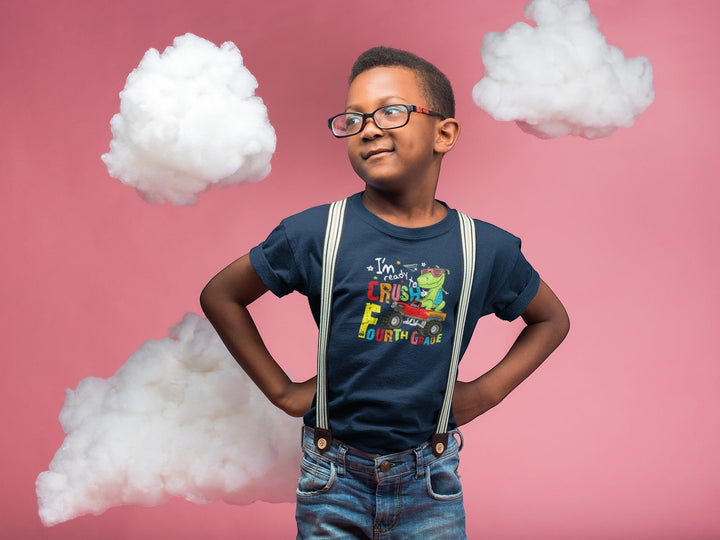 Sea Dragon Dreams navy blue cotton t-shirt with a dinosaur truck graphic for fourth grade, worn by a boy with glasses.