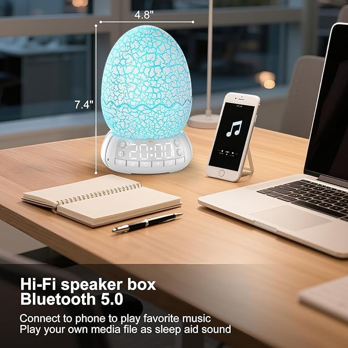 Sea Dragon Dreams dragon egg alarm clock with glowing blue light, Bluetooth speaker, and digital display on a desk.