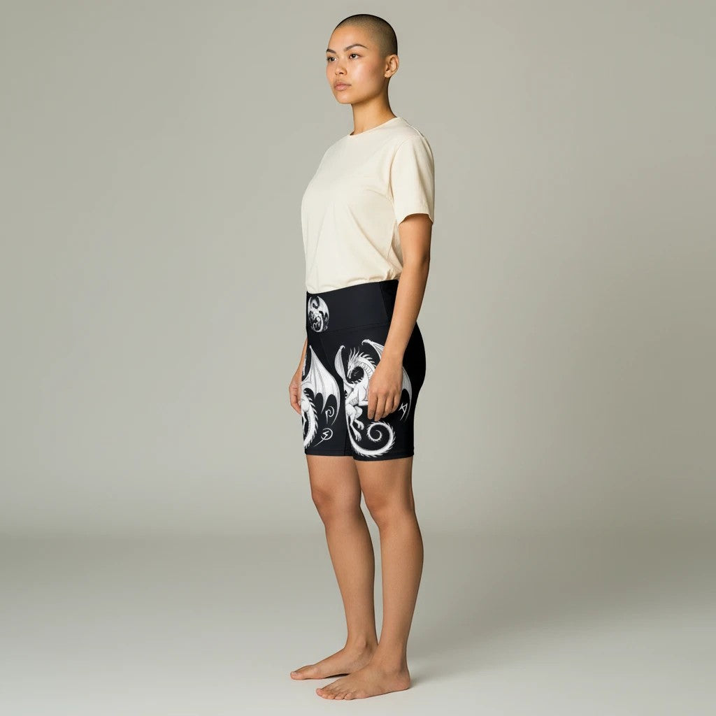Sea Dragon Dreams women's athletic shorts with white dragon print on black polyester fabric, side view on model.