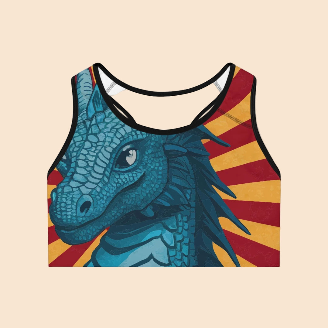 Sea Dragon Dreams sports bra featuring a blue dragon illustration against a red and yellow sunburst striped background