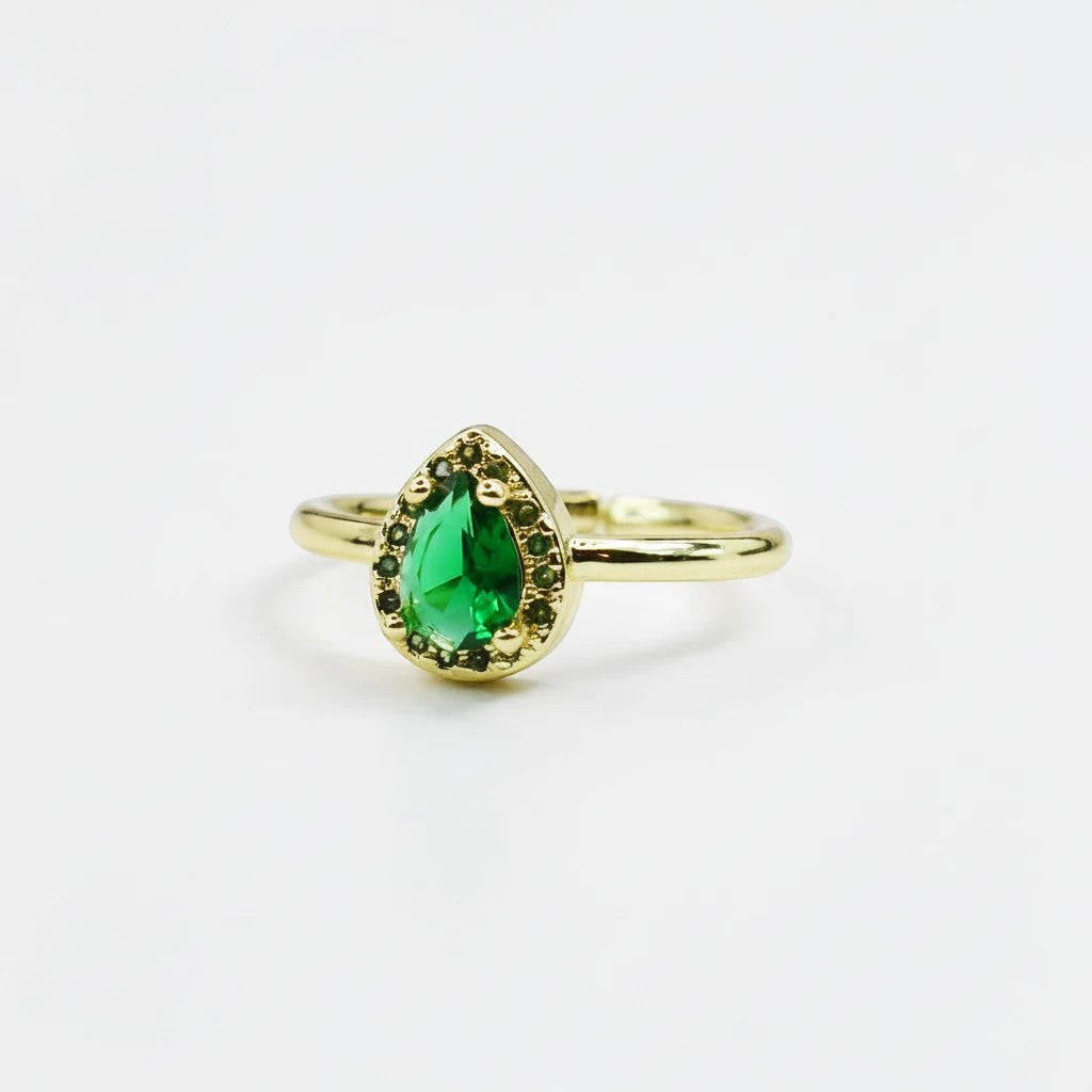 Sea Dragon Dreams emerald green teardrop crystal ring with a gold tone adjustable band on a white background.