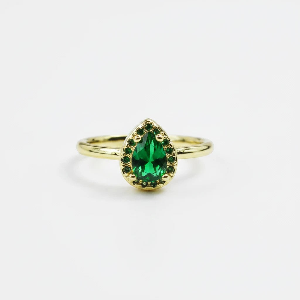 Sea Dragon Dreams emerald green teardrop crystal ring with a gold tone adjustable band on a white background
