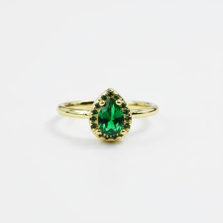 Sea Dragon Dreams emerald green teardrop crystal ring with a gold tone adjustable band on a white background