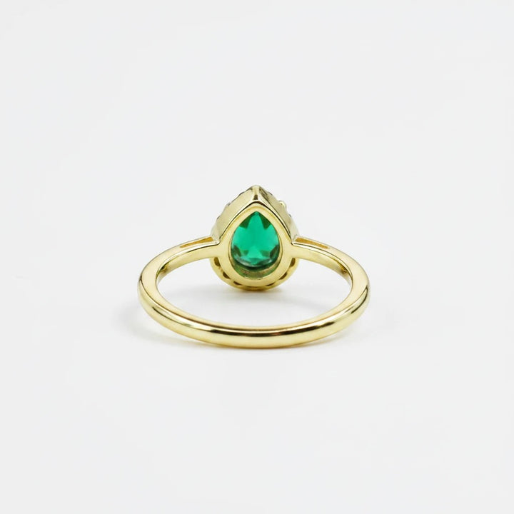 Sea Dragon Dreams adjustable gold tone ring featuring an emerald green teardrop crystal centerpiece