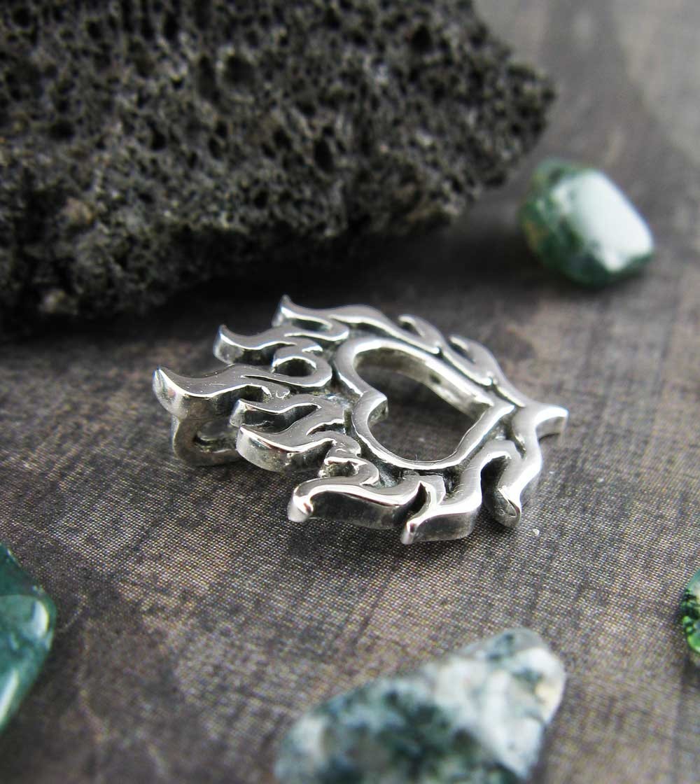 Sea Dragon Dreams handmade 925 sterling silver flaming heart pendant with oxidized details on a textured surface.