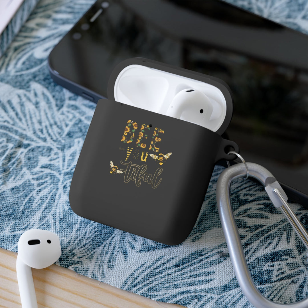 Sea Dragon Dreams Bee-You-Tiful floral AirPods case in black TPU with a bee design and metal carabiner on a patterned mat.