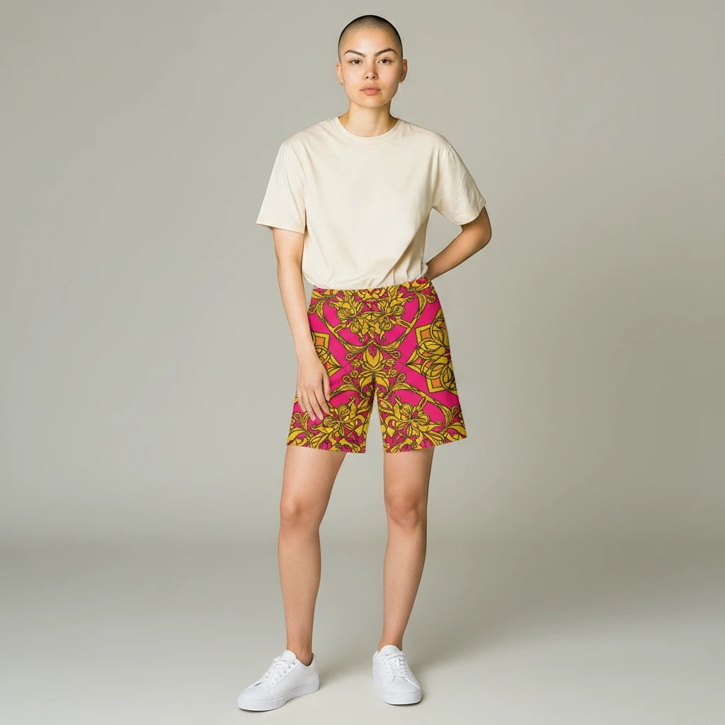 Sea Dragon Dreams women's bike shorts in pink and gold floral print, worn with a beige t-shirt and white sneakers.