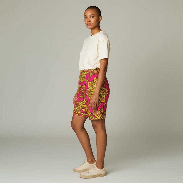 Sea Dragon Dreams women's bike shorts in pink and yellow floral print, worn by a model with a plain cream t-shirt.