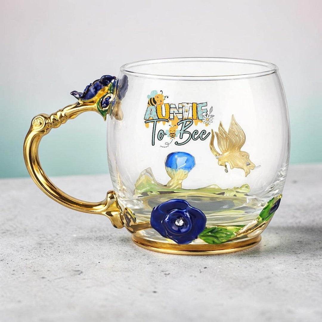 Sea Dragon Dreams Aunt to Bee glass mug with gold handle, enamel floral details, and a coordinating stirring spoon.