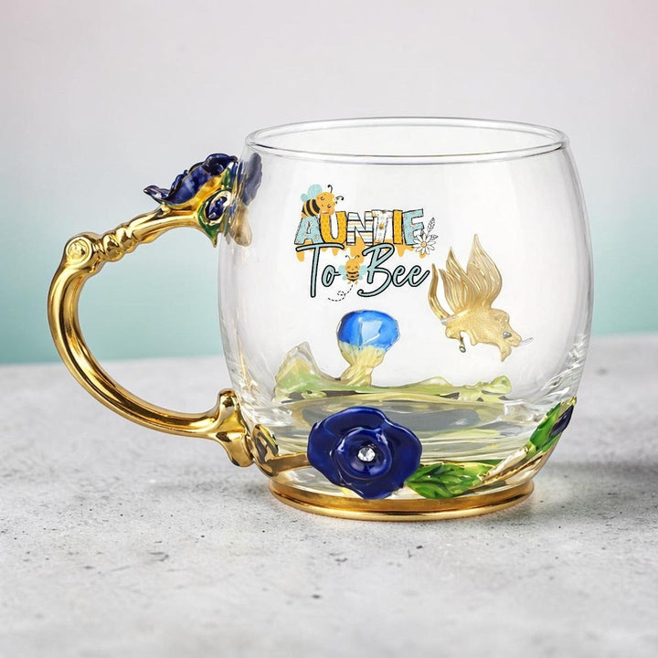 Sea Dragon Dreams Aunt to Bee glass mug with gold handle, enamel floral details, and a coordinating stirring spoon.