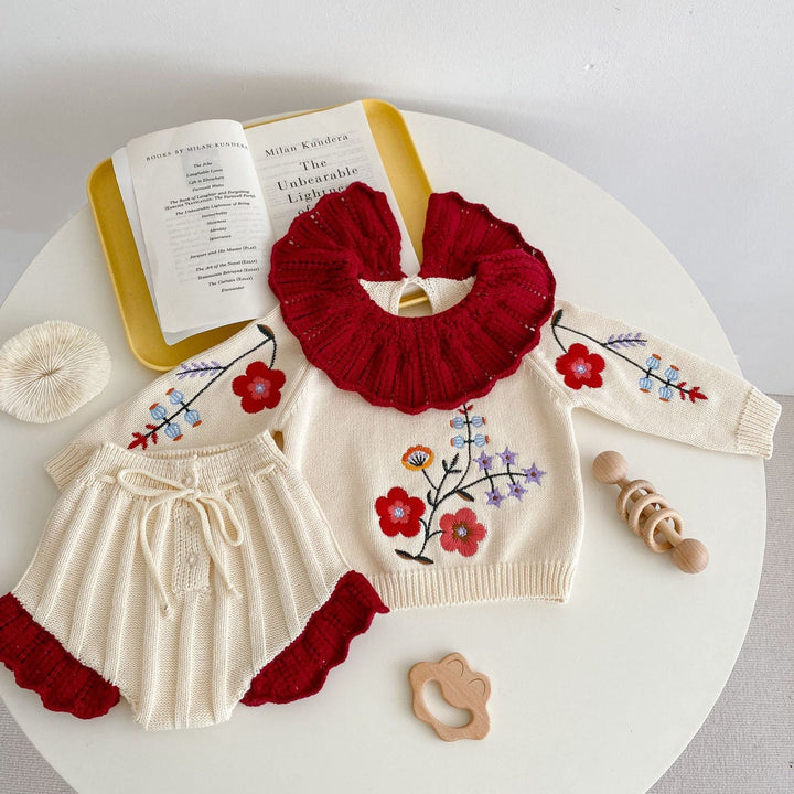 Sea Dragon Dreams baby girl knit set featuring an apricot blouse with floral embroidery and a red ruffled collar.