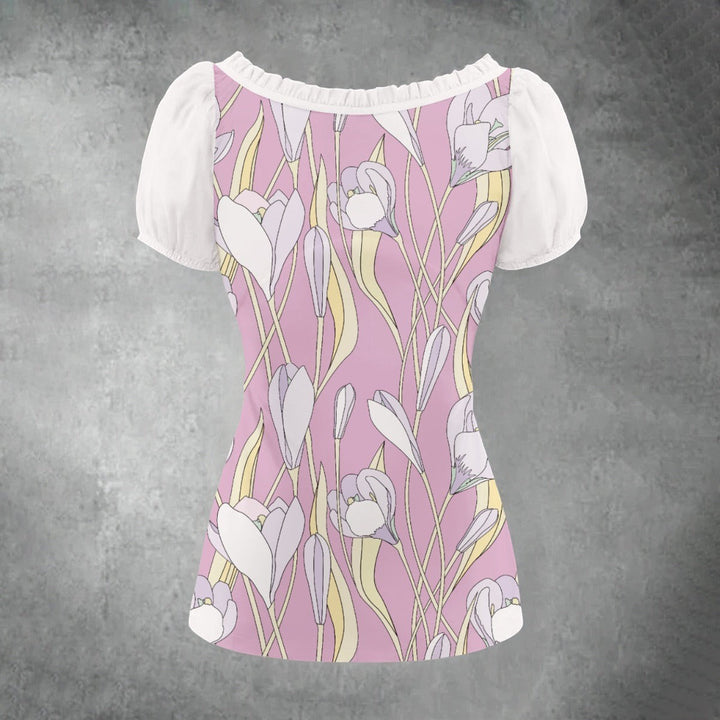 Sea Dragon Dreams floral puff-sleeve blouse with a pink background and white pleated details on a grey background.