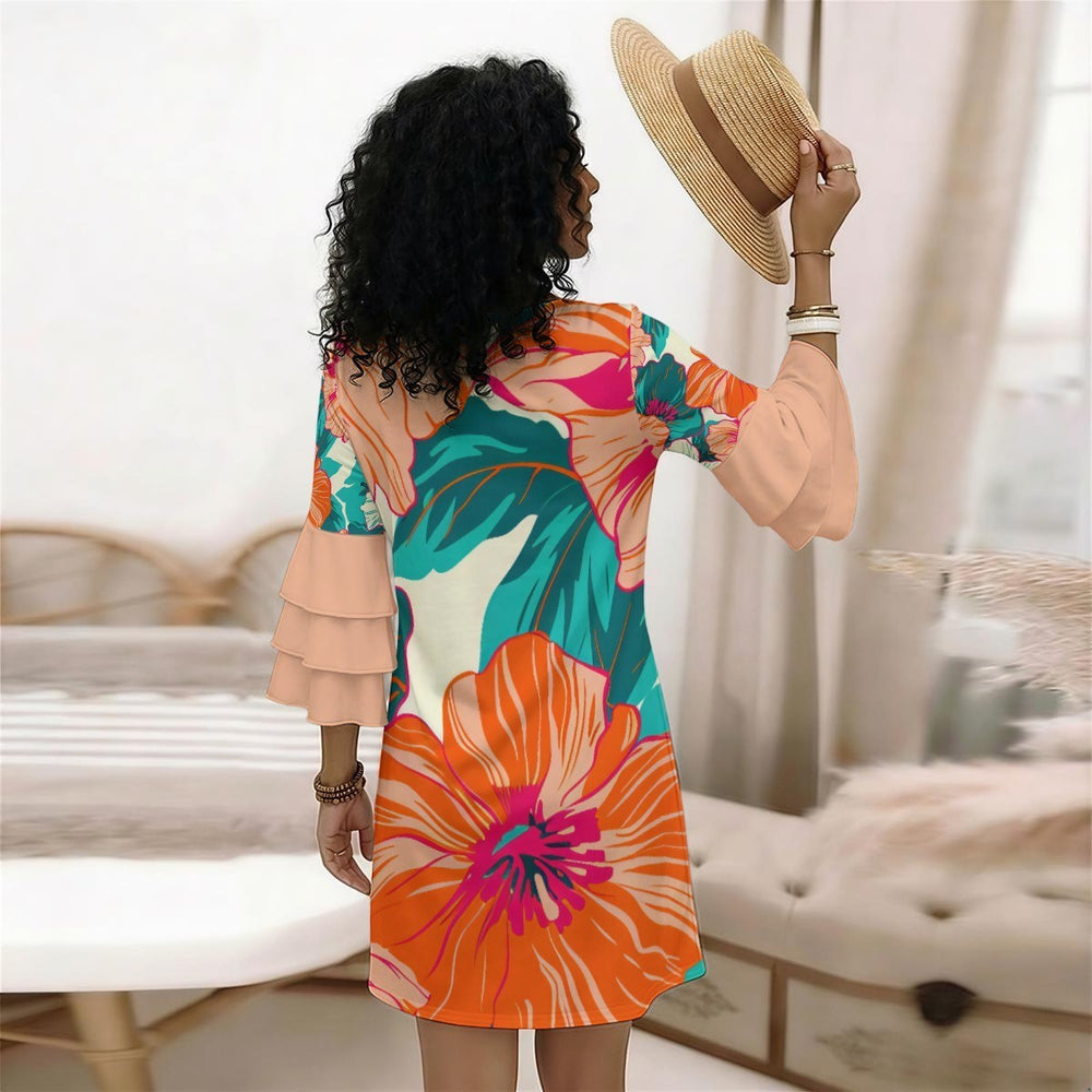 Sea Dragon Dreams floral print dress with tiered ruffle sleeves, worn by a woman holding a straw hat in a bedroom.