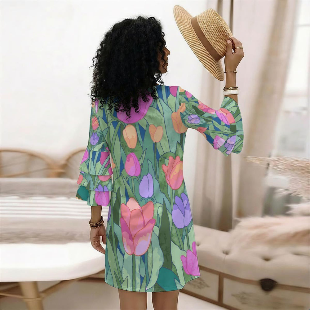 Sea Dragon Dreams floral print dress with tiered ruffle sleeves, worn by a woman holding a straw hat in a bedroom.