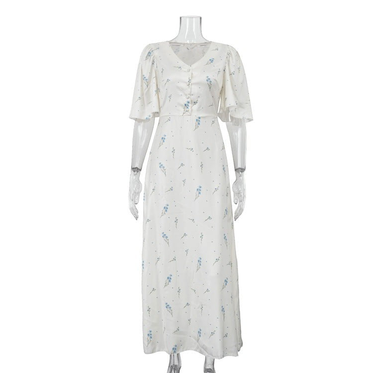 Sea Dragon Dreams white satin maxi dress with blue floral print, V-neckline, and flutter sleeves on a mannequin