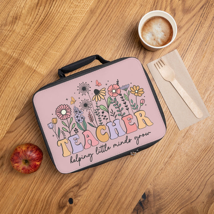 Sea Dragon Dreams insulated lunch bag with floral Teacher Helping Little Minds Grow design on a wooden table.
