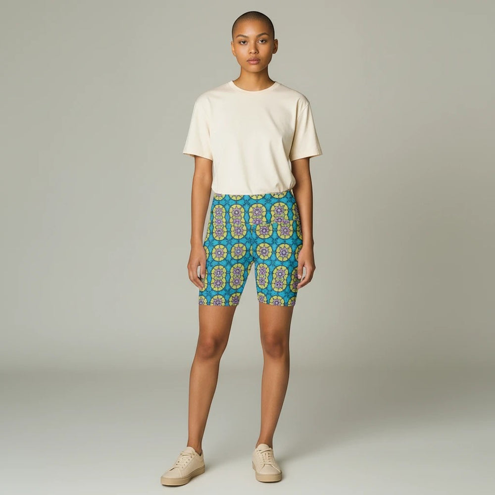 Model wearing Sea Dragon Dreams floral print workout shorts with a cream t-shirt and sneakers in a studio setting.