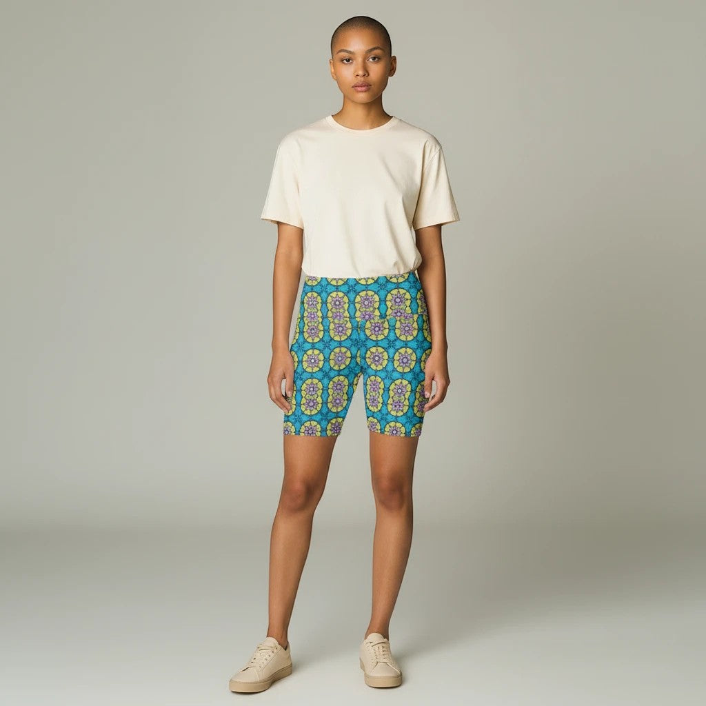 Model wearing Sea Dragon Dreams floral print workout shorts with a cream t-shirt and sneakers in a studio setting.