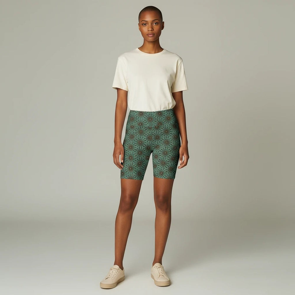 Model wearing Sea Dragon Dreams Earthly Harmony floral workout shorts in green with a cream t-shirt and sneakers.