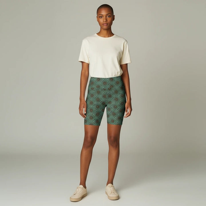 Model wearing Sea Dragon Dreams Earthly Harmony floral workout shorts in green with a cream t-shirt and sneakers.
