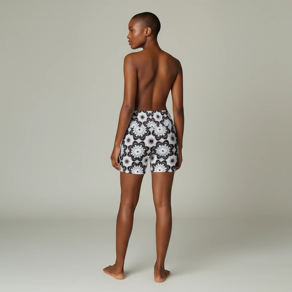 Model wearing Sea Dragon Dreams workout shorts with a black and white floral mandala pattern, back view.