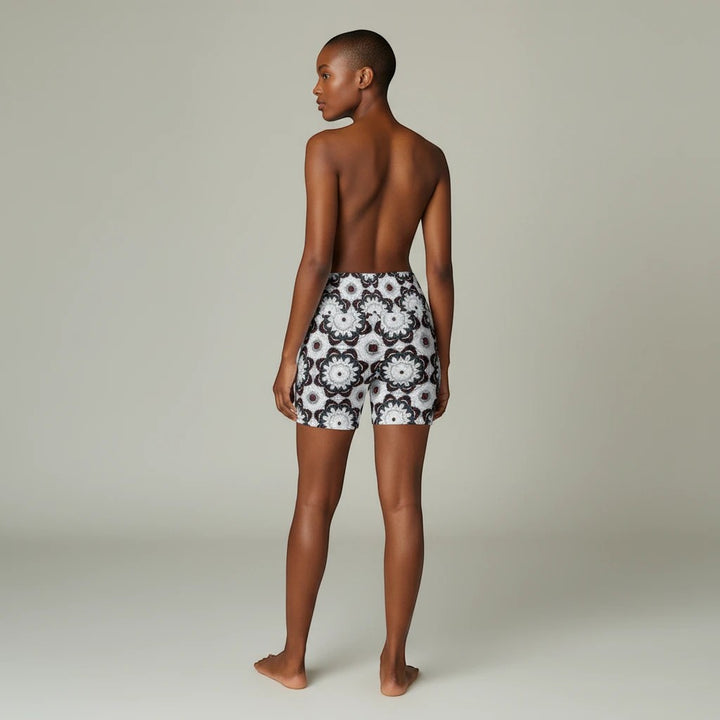 Model wearing Sea Dragon Dreams workout shorts with a black and white floral mandala pattern, back view.
