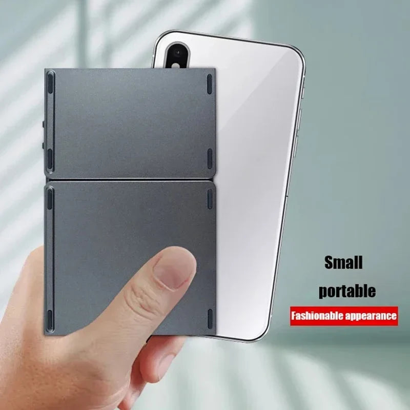 Sea Dragon Dreams foldable Bluetooth keyboard in a compact grey finish held next to a smartphone for size comparison